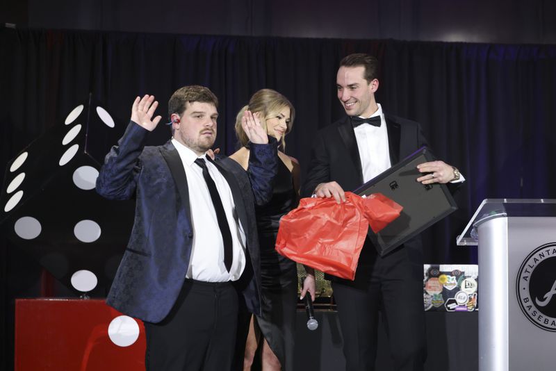 Atlanta Braves first baseman Matt Olson and his wife Nicole react as they receive a gift from Reece Blankenship during Diamond Casino Night at the Delta Club in Truist Park, Friday, January 27, 2023, in Atlanta. Reece Blankenship is a non-verbal autistic who Olson has known since middle school. The fundraiser will benefit the ReClif Community, which aims to provide a chance for more typical life experiences for individuals living with autism and those that care for them. (Jason Getz / Jason.Getz@ajc.com)