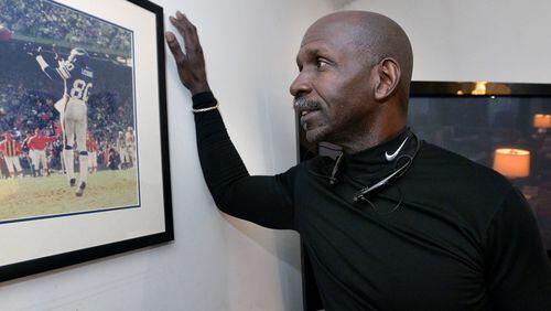 Terry LeCount looks at a photo from his years as an NFL player with the Minnesota Vikings. LeCount struggled with addiction but went on to spend a decade as a paraprofessional at Oakhurst Elementary School in Decatur and now works at the College Football Hall of Fame Museum. HYOSUB SHIN / HSHIN@AJC.COM