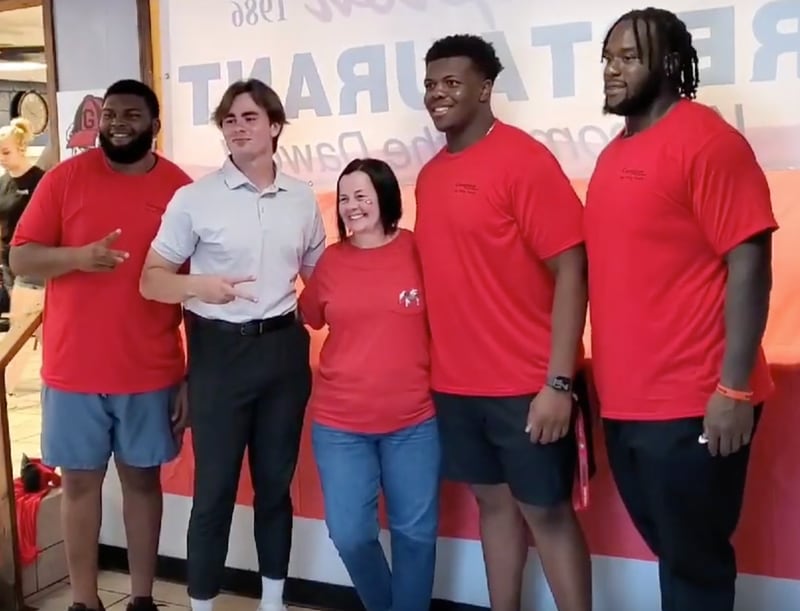 Georgia quarterback JT Daniels (light shirt) poses with teammates Jamaree Salyer (L), Warren McClendon and Justin Shaffer (far right) along with a Bulldogs fan during a paid promotional appearance at Campton Restaurant in Monroe on July 28, 2021. (Photo from Campton Restaurant)