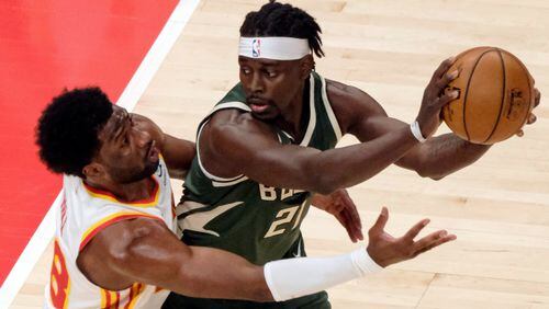 Hawks forward Solomon Hill (18) wraps up Milwaukee Bucks guard Jrue Holiday (21) during the first half Sunday, April 25, 2021, at State Farm Arena in Atlanta. (Ben Gray/AP)