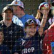 An young Atlanta Braves fan holds up a baseball asking for an autograph during spring training workouts at CoolToday Park, Wednesday, Feb. 21, 2024, in North Port, Florida. (Hyosub Shin / Hyosub.Shin@ajc.com)