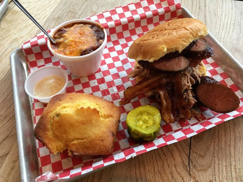 A sandwich with sausage, bacon and pulled pork is accompanied by brisket chili and jalapeno cornbread at King Barbecue. CONTRIBUTED BY WYATT WILLIAMS