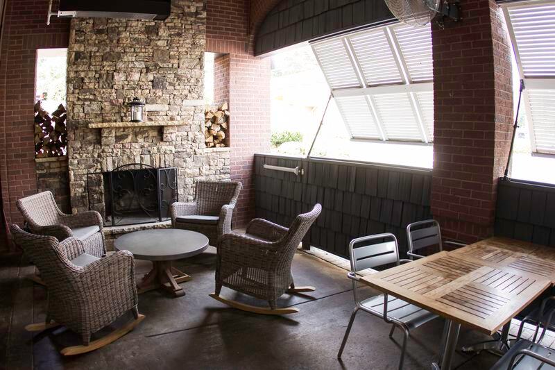 Common Quarter features outdoor dining under a fully covered patio with a brick fireplace. / Photo credit: Michael Mussman