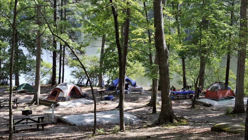 Campers pitch their tents in the woods by the lake at Stone Mountain Park in this 2010 photo. Stone Mountain Park recently added three new yurts nestled lakeside in the park’s popular campground. The new homes away from home are made of wood and canvas, featuring outside decks, picnic tables, charcoal grills, a fire pit and large water spigots for camping convenience. Inside each yurt, comfort awaits in the form of log furniture, heat and AC, electric outlets, large windows, skylights, ceiling fans, lockable doors and sleeping space for up to five guests. All a camper needs to bring is a sleeping bag or linens and personal items. AJC FILE PHOTO