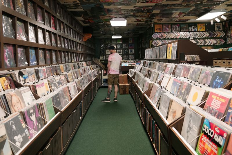 Jeff Maimon, of Chicago, checks out some vinyl at Tracks In Wax record shop, Thursday, April 18, 2024, in Phoenix. Special LP releases, live performances and at least one giant block party are scheduled around the U.S. Saturday as hundreds of shops celebrate Record Store Day amid a surge of interest in vinyl and the day after the release of Taylor Swift's latest album. (AP Photo/Ross D. Franklin)