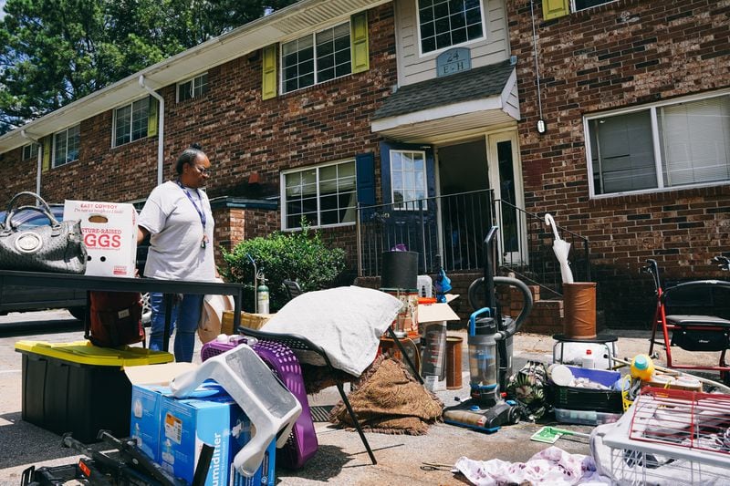 Constance Alford of Atlanta looks over her belongings after workers hauled them to the parking lot during a July eviction from her Pavilion Place apartment. She said she had been living there for 10 years. (Olivia Bowdoin for The Atlanta Journal-Constitution) 