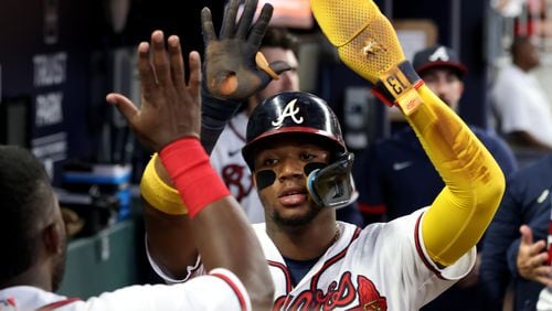 Braves right fielder Ronald Acuña celebrates a run with teammates after Austin Riley doubled during the fifth inning against the Dodgers on Saturday night. Acuña was not in Sunday’s lineup. (Jason Getz / Jason.Getz@ajc.com)
