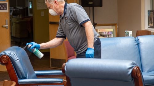 David Fiskum sprays down furniture with sanitizer at the Frank Bailey Senior Center last week during the county's deep cleaning and sanitizing of the building in preparation for the upcoming public reopening.