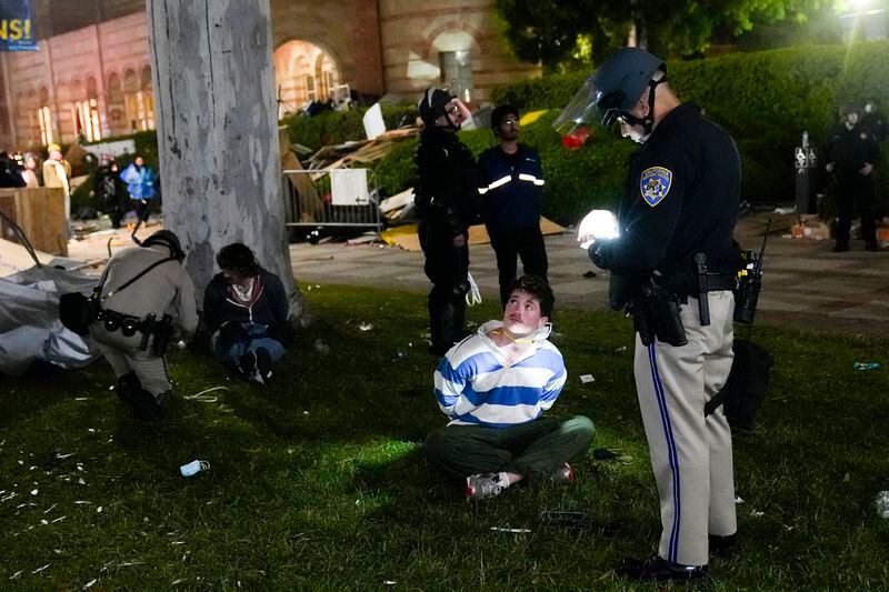 FILE - Demonstrators are detained by police in an encampment set up by pro-Palestinian demonstrators on the UCLA campus Thursday, May 2, 2024, in Los Angeles. (AP Photo/Jae C. Hong, File)