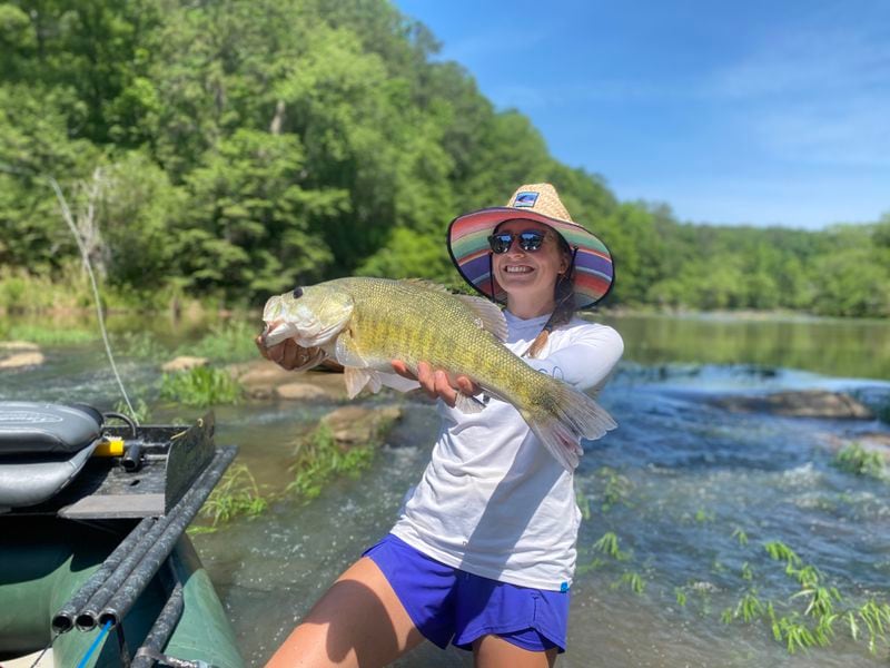 Jamie Rogers posts with a shoal bass caught on fly tackle in the spring of 2023 downstream of Yellow Jacket Shoals on the Flint River. Rogers is the daughter of Gordon Rogers, executive director of the Flint Riverkeeper. Photo courtesy of Rogers family.