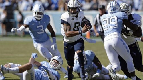 Georgia Tech's Tobias Oliver (8) runs the ball while North Carolina's J.K. Britt (29) misses the tackle during the first half of an NCAA college football game in Chapel Hill, N.C., Saturday, Nov. 3, 2018. (AP Photo/Gerry Broome)