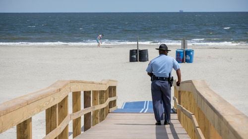 A Georgia State Patrol officer keeps watch at Tybee Island beach last year during social distancing efforts during the coronavirus pandemic. A 15-year-old Alabama girl died Saturday after being struck by lightning while swimming in the area, according to reports.