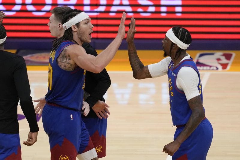 Denver Nuggets forward Aaron Gordon, left, high-fives guard Kentavious Caldwell-Pope during the second half of Game 3 of an NBA basketball first-round playoff series against the Los Angeles Lakers in Los Angeles, Thursday, April 25, 2024. (AP Photo/Ashley Landis)