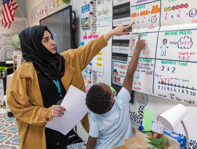 Shakila Aimaq (left), a recent Afghan refugee who is studying to become a teacher, helps a student in Taylor Thomas' kindergarten class at the International Community School in Decatur. PHIL SKINNER FOR THE ATLANTA JOURNAL-CONSTITUTION