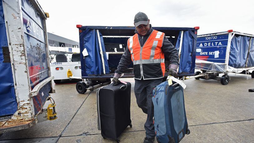 Delta baggage crew Stanley Hooks loads bags at Hartsfield-Jackson International Airport on Wednesday, February 27, 2019. HYOSUB SHIN / HSHIN@AJC.COM