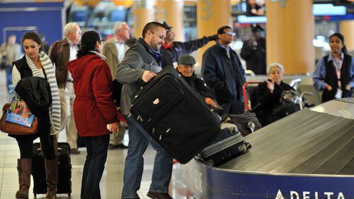 November 18, 2014 Atlanta - Travelers wait at baggage claim area at Hartsfield-Jackson International Airport on Tuesday, November 18, 2014. HYOSUB SHIN / HSHIN@AJC.COM