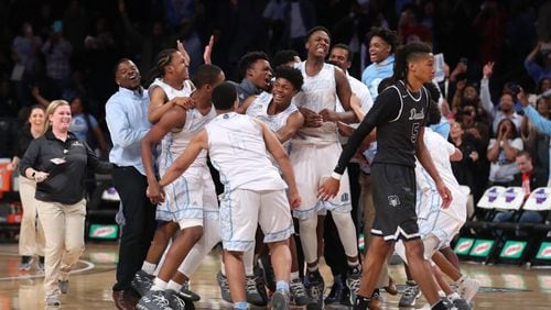 Meadowcreek players celebrate their win Saturday night as Norcross forward Joseph Toppin (5, right) walks off of the court after the  Class AAAAAAA boys championship game at McCamish Pavilion. Meadowcreek won 56-43.