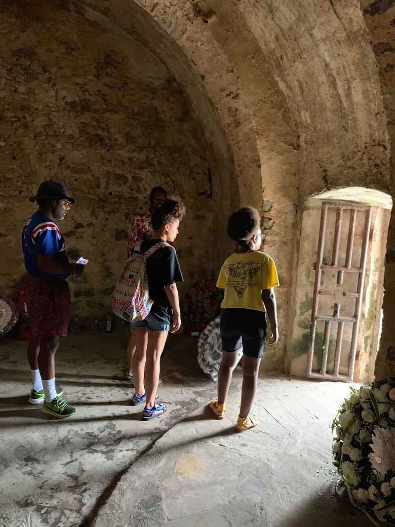 Nene Kisseih, his daughters Korleki and Audri Kisseih and his cousin Gabriella look out of Elmina Castle’s Door of No Return. The door is adorned with gifts and wreaths left by others.