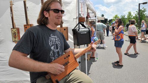 Cigar box guitars, like this one played by Mike Snowden of Marietta during the Old Fourth Ward Park Arts Festival, will be available for checkout from Fulton County libraries.