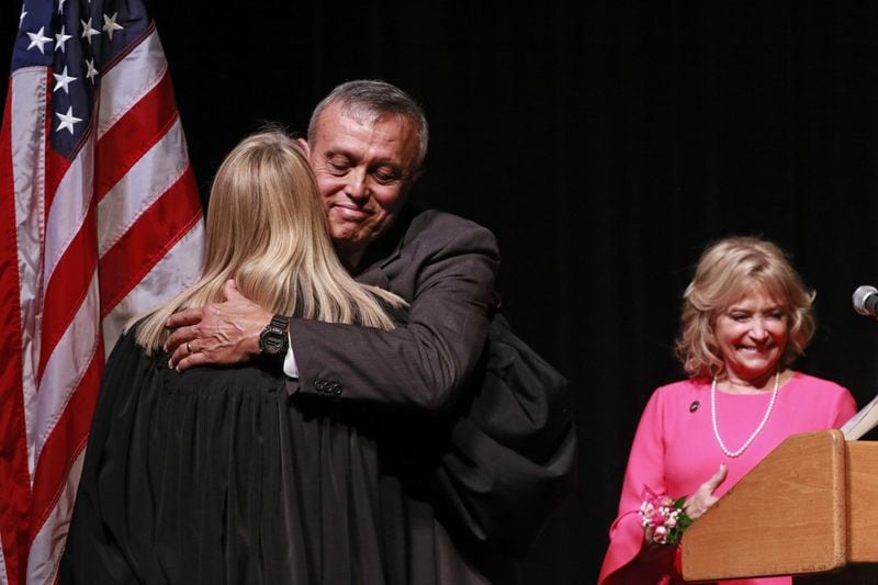 Mike Boyce hugs Cobb State Court Judge Marsha Lake after he was sworn in. At right is his wife, Judy. In a ceremony at the Cobb Civic Center, Mike Boyce was sworn in as Cobb County’s next chair. (BOB ANDRES /BANDRES@AJC.COM)