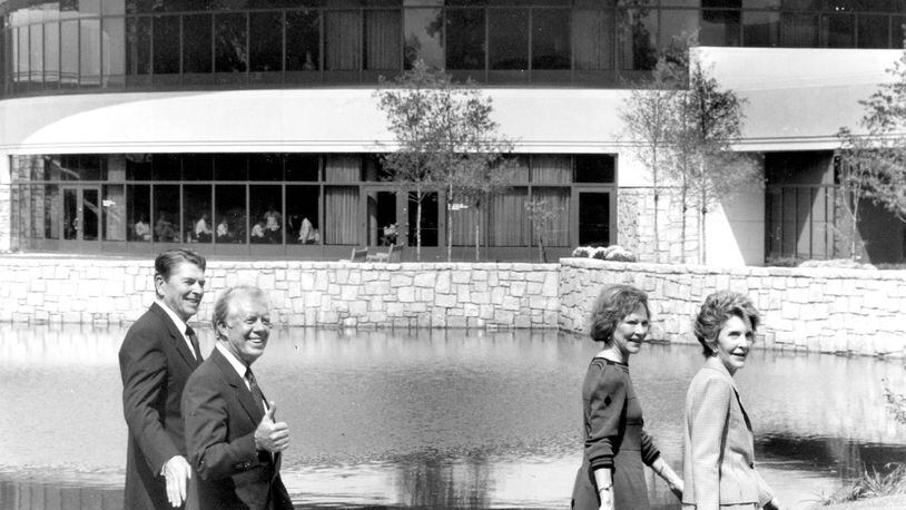 Jimmy Carter gives a thumbs-up sign as he and Rosalynn give a tour of the Carter Center to Ronald and Nancy Reagan.
