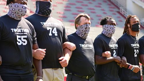 Georgia offensive lineman Trey Hill (55), offensive lineman Ben Cleveland (74), Coach Kirby Smart, defensive back Richard LeCounte (2), and defensive back Eric Stokes (27) stand together before the Bulldogs' game with Arkansas in Fayetteville, Ark., on Saturday, Sept. 26, 2020. (Photo by Kevin Snyder)