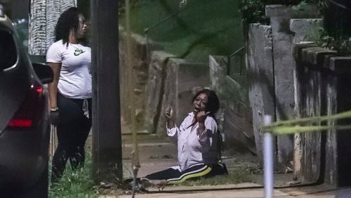 A woman filled with emotion cries on the sidewalk along Sunset Avenue. Two people were killed and two others were injured early Friday, July 24, 2020, when gunfire erupted outside a house party in northwest Atlanta's Vine City neighborhood, authorities said. The victims had just gotten out of a ride-share vehicle on Sunset Avenue about 2:30 a.m. when two suspects opened fire on them, Atlanta police Lt. Pete Malecki told reporters outside the home. (JOHN SPINK/JSPINK@AJC.COM)