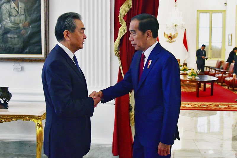 In this photo provided by the Indonesian Presidential Palace, Chinese Foreign Minister Wang Yi , left, shakes hands with Indonesia President Joko Widodo during a meeting at the palace in Jakarta, Indonesia, Thursday, April 18, 2024. The Chinese and Indonesian foreign ministers called for an immediate and lasting cease-fire in Gaza after a meeting in Jakarta on Thursday, condemning the humanitarian costs of Israel's ongoing war against Hamas. (Vico/Indonesian Presidential Palace via AP)