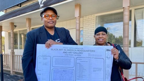 Najee Dorsey and his wife Seteria hold up the plans for their new art center in East Point.