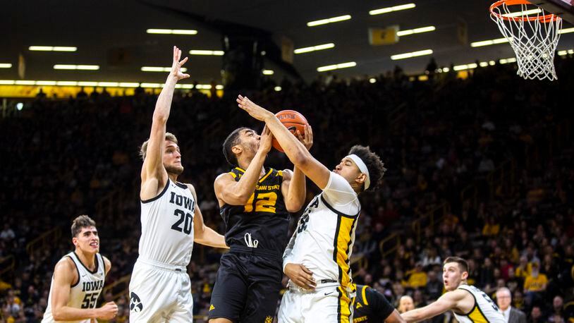 Kennesaw State guard Jamie Lewis (12) drives to the basket in between Iowa forwards Cordell Pemsl and Riley Till (20) Sunday, Dec. 29, 2019, in Iowa City, Iowa.
