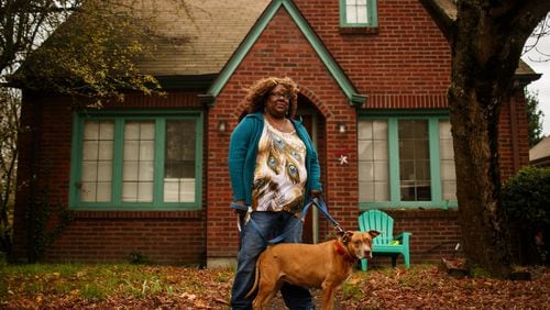 Brendi London is photographed with her service dog, Ruby, outside their home in Northeast Seattle on November 14, 2017. Due to an upcoming University Unitarian Church renovation, London's house and two others will be replaced with parking spots. London says the last two places she has lived have been also torn down. "I feel like they are exterminating my past," she says. (Erika Schultz/Seattle Times/TNS)