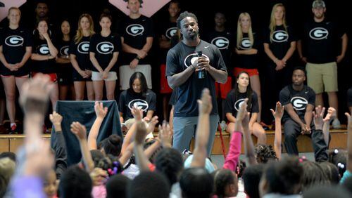 Former UGA football player Keith Marshall engages with students at D.H. Stanton Elementary School in 2015. The school is one of several that Atlanta Public Schools is planning to consolidate, causing some students to shift to new schools and job changes for staff. BRANT SANDERLIN/BSANDERLIN@AJC.COM