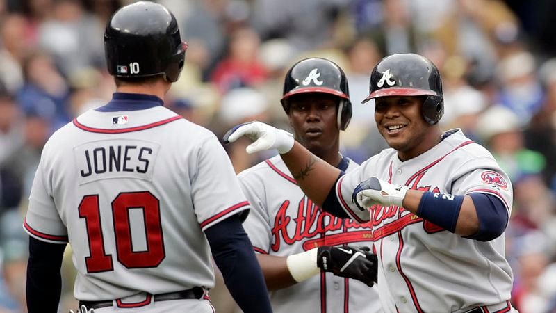 Braves' Andruw Jones (right) is greeted by teammates Chipper Jones (left) and Edgar Renteria after he hit a three-run homer off Dodgers pitcher Derek Lowe in the fifth inning of the season opener in Los Angeles on Monday, April 3, 2006.