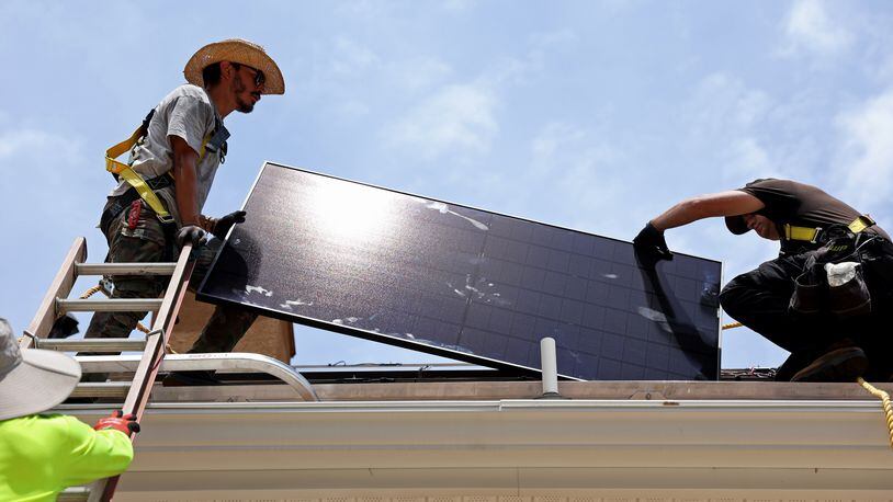 060722 Ellenwood: Alternative Energy Southeast employees Aaron Basto, center, and Russell McCune, right, installs one of eighteen solar panels to the roof of a resident Tuesday, June 7, 2022, in Ellenwood, Ga. (Jason Getz / Jason.Getz@ajc.com)
