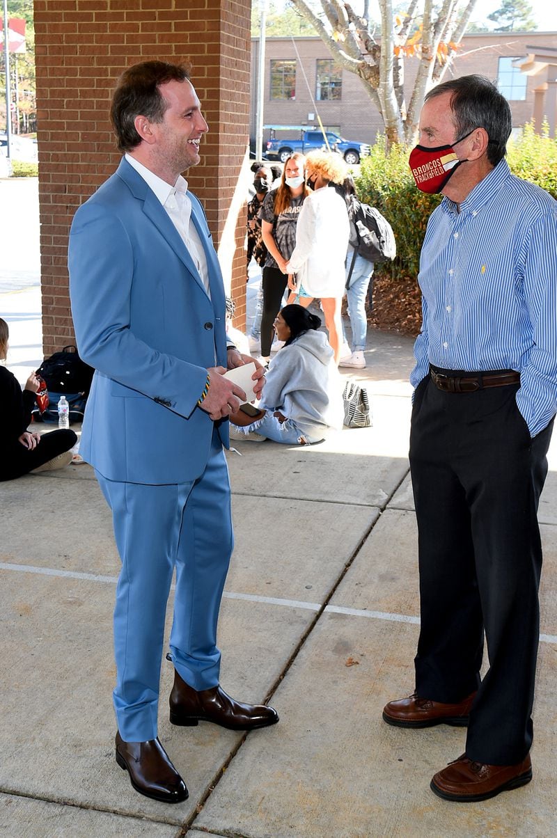 ATLANTA, GEORGIA - DECEMBER 02: Airbnb co-founder Joe Gebbia Jr. talks with his retired cross-country coach, Joe Carter, at Brookwood High School. Gebbia is donating more than $200,000 to the cross-country team and $500,000 to the art program at his alma mater.(Photo by Marcus Ingram/Getty Images for Brookwood High School)