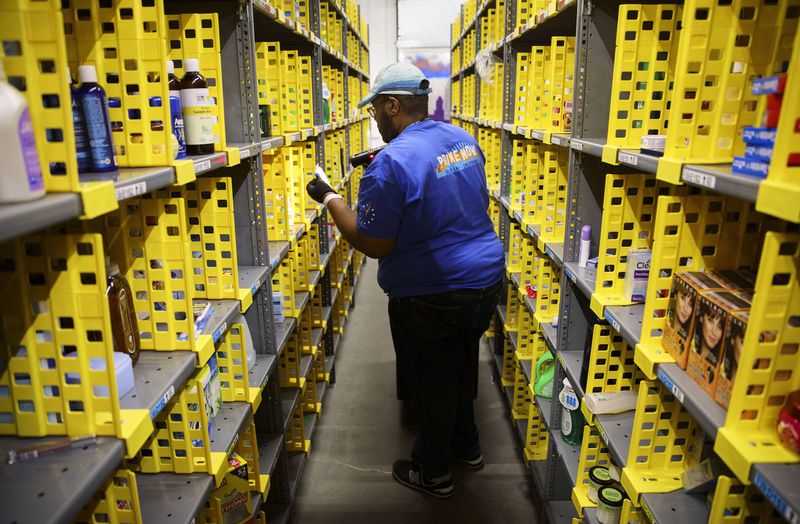Ryan White, an Amazon associate, fills shopping bags for customer orders at a warehouse in Los Angeles. (Patrick Fallon/Zuma Press/TNS)