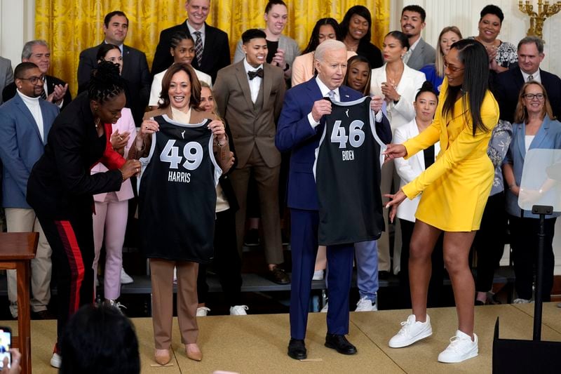 A'ja Wilson, right, and Chelsea Gray, left, of the WNBA's Las Vegas Aces, present jerseys to President Joe Biden, center right, and Vice President Kamala Harris, center left, during an event to celebrate the 2023 WNBA championship team, in the East Room of the White House, Thursday, May 9, 2024, in Washington. (AP Photo/Evan Vucci)