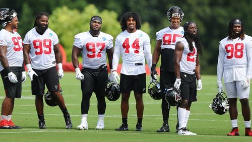 Falcons defenders Michael Bennett (from left), Adrian Clayborn, Grady Jarrett, Vic Beasley, Jack Crawford, Desmond Trufant and Takk McKinley watch the third string defense from the sidelines during the first practice of training camp Monday, July 22, 2019, in Flowery Branch.
