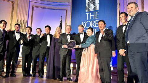 Gov. Brian Kemp, center, is joined by officials from the state, Hyundai Motor Group and other business and diplomatic officials at the annual Korea Society dinner. The state was honored with the Gen. James A. Van Fleet Award for its economic alliance with Korea. (J. Scott Trubey/AJC)