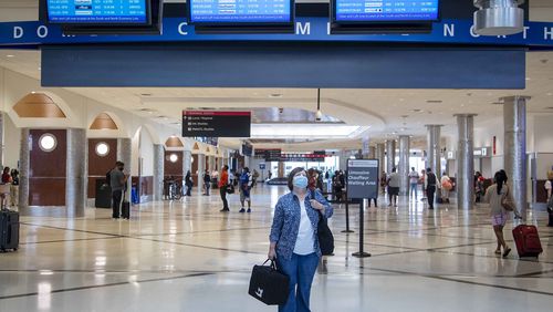 Carol Lutz of Texas wears a mask as she looks to screen to find the carousel that has her luggage in the domestic terminal at Hartsfield-Jackson Atlanta International Airport, Friday, September 4, 2020. (Alyssa Pointer / Alyssa.Pointer@ajc.com)
