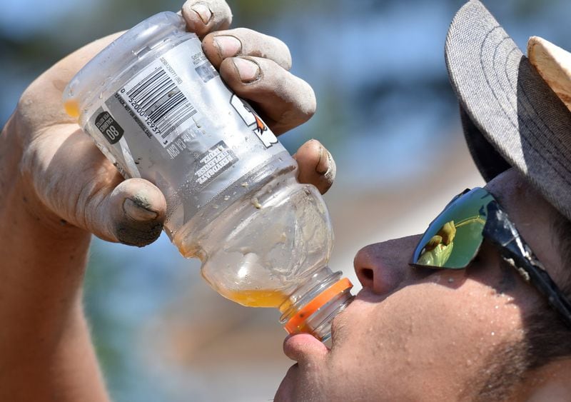 As temperatures keep reaching into the 90s in Atlanta, it’s important to stay hydrated. Construction worker Ismael Oro takes a break from the heat in a new subdivision under construction by Taylor Morrison in Duluth last week. 