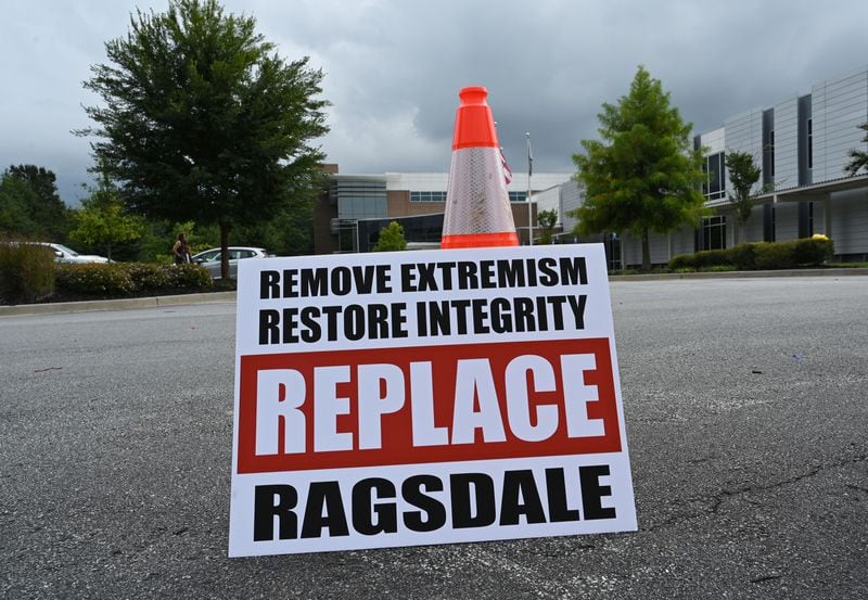 A sign is displayed as a group of Cobb community members rallies to demand the removal of Superintendent Chris Ragsdale outside Cobb County School District building, Thursday, September 14, 2023, in Marietta. (Hyosub Shin/hyosub.shin@ajc.com)