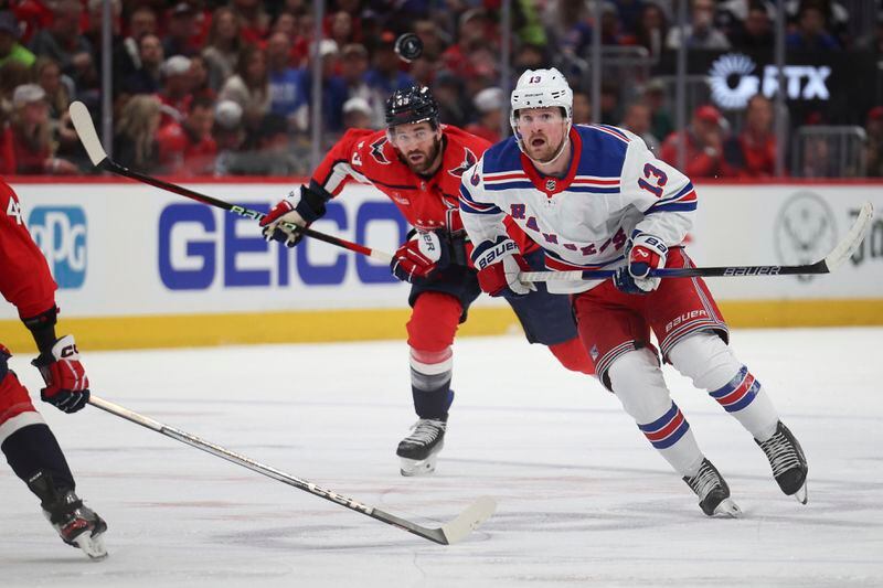 New York Rangers left wing Alexis Lafrenière (13) chases the puck beside Washington Capitals right wing Tom Wilson (43) during the second period in Game 3 of an NHL hockey Stanley Cup first-round playoff series, Friday, April 26, 2024, in Washington. (AP Photo/Tom Brenner)