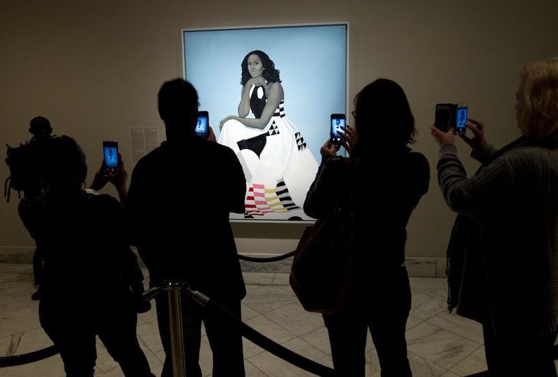 Visitors take pictures of the official portrait of the former first lady Michelle Obama in the first day open exhibit at the Smithsonian's National Portrait Gallery, Tuesday, Feb. 13, 2018, in Washington.