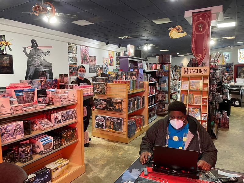 Tony Cade, owner of Challenges Games & Comics in North DeKalb Mall, has a strong customer base but wonders if he can afford the significantly higher rent in the proposed new development.  Associate Khayman Bliss in the background.  Photo by Bill Torpy