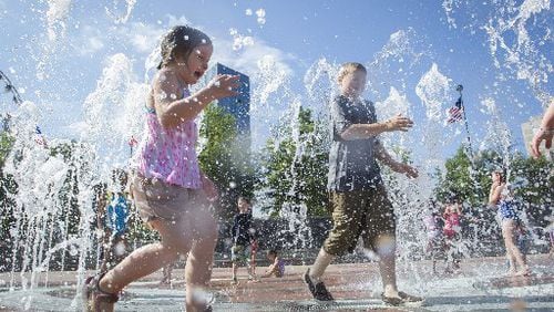 Children play in the fountain at Centennial Olympic Park. Bank of America announced Thursday a $1 million donation to expand and update the 21-acre downtown greenspace.