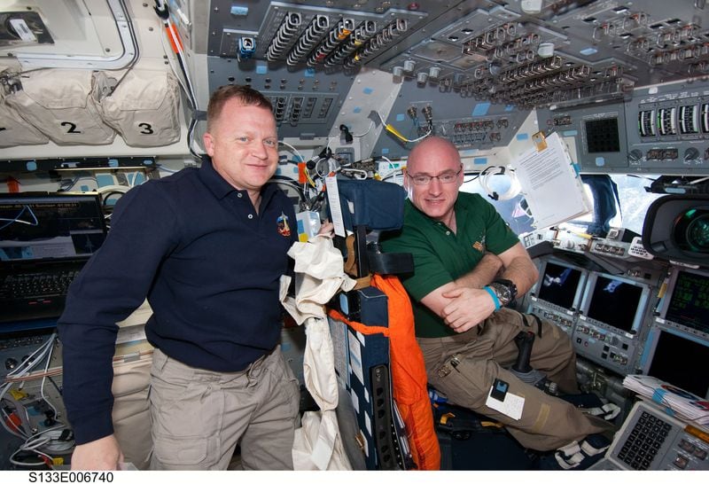 In this February 2011 file photo, NASA astronauts Eric Boe (left), STS-133 pilot; and Scott Kelly, Expedition 26 commander, take a moment for a photo on the flight deck of space shuttle Discovery while docked with the International Space Station. Photo credit: NASA