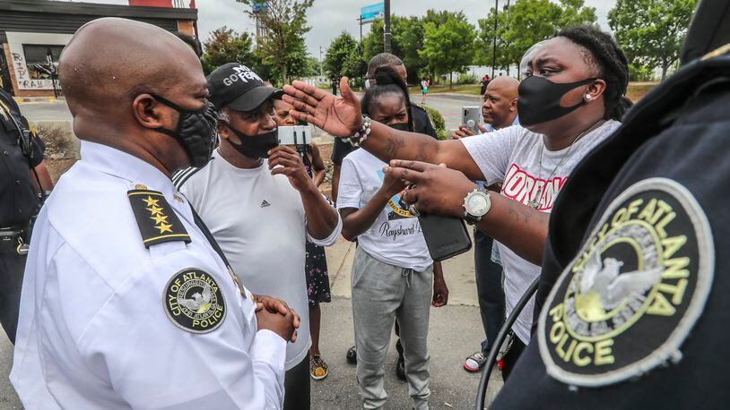July 6, 2020 Atlanta: Interim Atlanta Police Chief Rodney Bryant (left)  listens to a woman who identified herself as Lady A where Atlanta police and sanitation crews finished removing protesters and their belongings from outside the Wendyâs on Monday July 6, 2020 where Rayshard Brooks was shot and killed by an officer last month. The last concrete barricade was put in place around noon. Some of the protesters milled nearby while a worker from the BP gas station next door pulled boards off the windows. Mondayâs cleanup followed a violent holiday weekend that started Saturday night when 8-year-old Secoriea Turner was fatally shot while sitting in a car near the restaurant. Atlanta Mayor Keisha Lance Bottoms denounced the violence in an emotional press conference at police headquarters in which she and Turnerâs family urged people to come forward with information about the girlâs killers. About 9:30 a.m. Monday, uniformed officers and multiple workers in neon attire tossed flowers and other items from a makeshift memorial outside the Wendyâs into garbage bags. The site has served as ground zero for protests since Brooks was shot in the parking lot following an attempted DUI arrest in the drive-thru line June 12. The restaurant was destroyed during a large protest the next day. Three people have been arrested on arson charges in connection with the incident. JOHN SPINK/JSPINK@AJC.COM