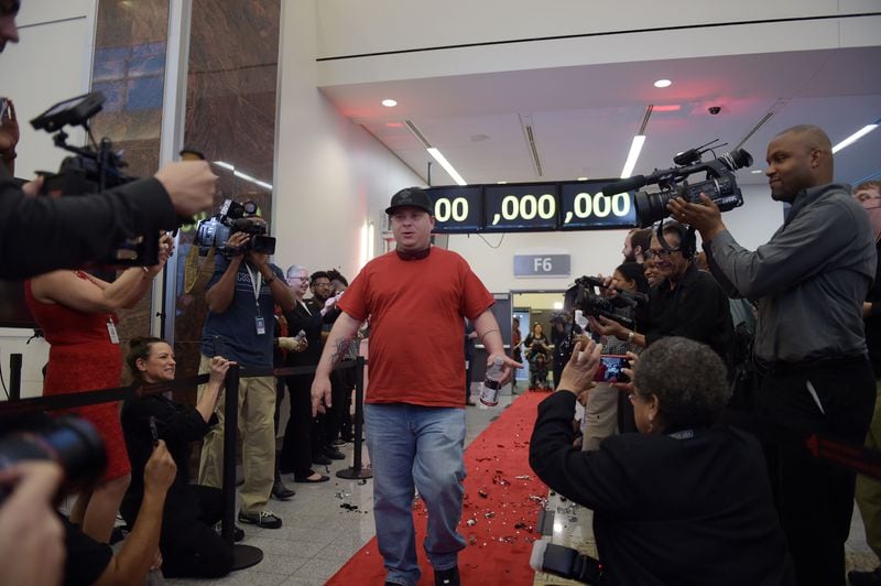 DECEMBER 27, 2015 ATLANTA Passenger Larry Kendrick arrives with full media attention from Gulfport MS. Hartsfield-Jackson International Airport awarded its 100 millionth passenger for 2015 with prizes including a new car, two free airline tickets and a small crowd of officials and television cameras early Sunday December 27, 2015. The Atlanta airport — the world’s busiest — is the first airport in the world to handle 100 million passengers in a year. “It’s our commitment that we maintain our position as the world’s most traveled airport,” said Atlanta Mayor Kasim Reed during remarks at the airport before the flight arrived Sunday morning. The winner, a man from Biloxi named Larry Kendrick who arrived at the airport in blue jeans, an orange t-shirt and a baseball cap, was surprised to learn upon landing that he had been selected as the 100 millionth passenger. KENT D. JOHNSON/ kdjohnson@ajc.com
