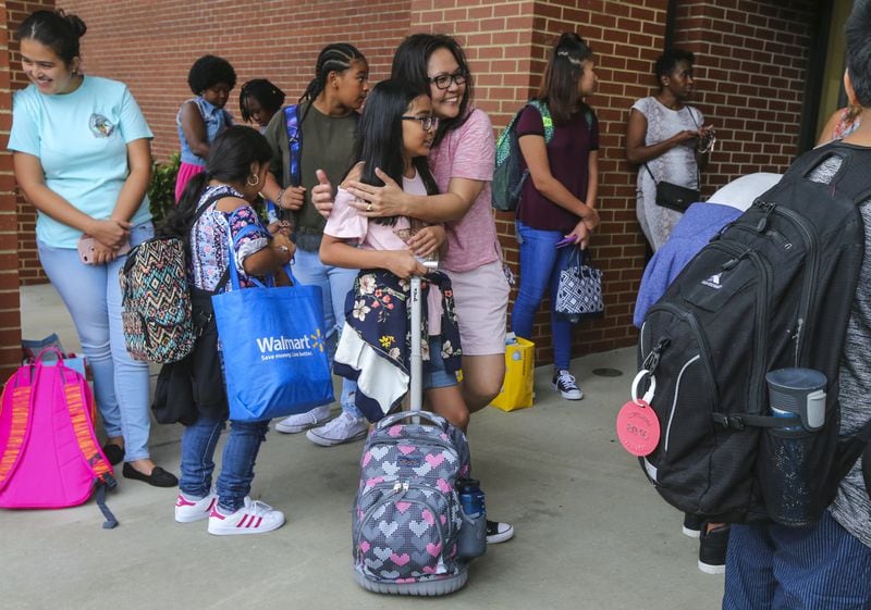 Gwinnett County’s deep diversity is evident in its schools. Here, Myrna Gacusan gives 11-year old Rinna a hug before she begins her school day at Coleman Middle School in Duluth on August 7, 2017. The 1996 Summer Olympics in Atlanta triggered a population boom — and international immigrants — in the Atlanta area. With a school system that was already beginning to be considered among the best in the Southeast, Gwinnett County was a popular destination. JOHN SPINK/JSPINK@AJC.COM